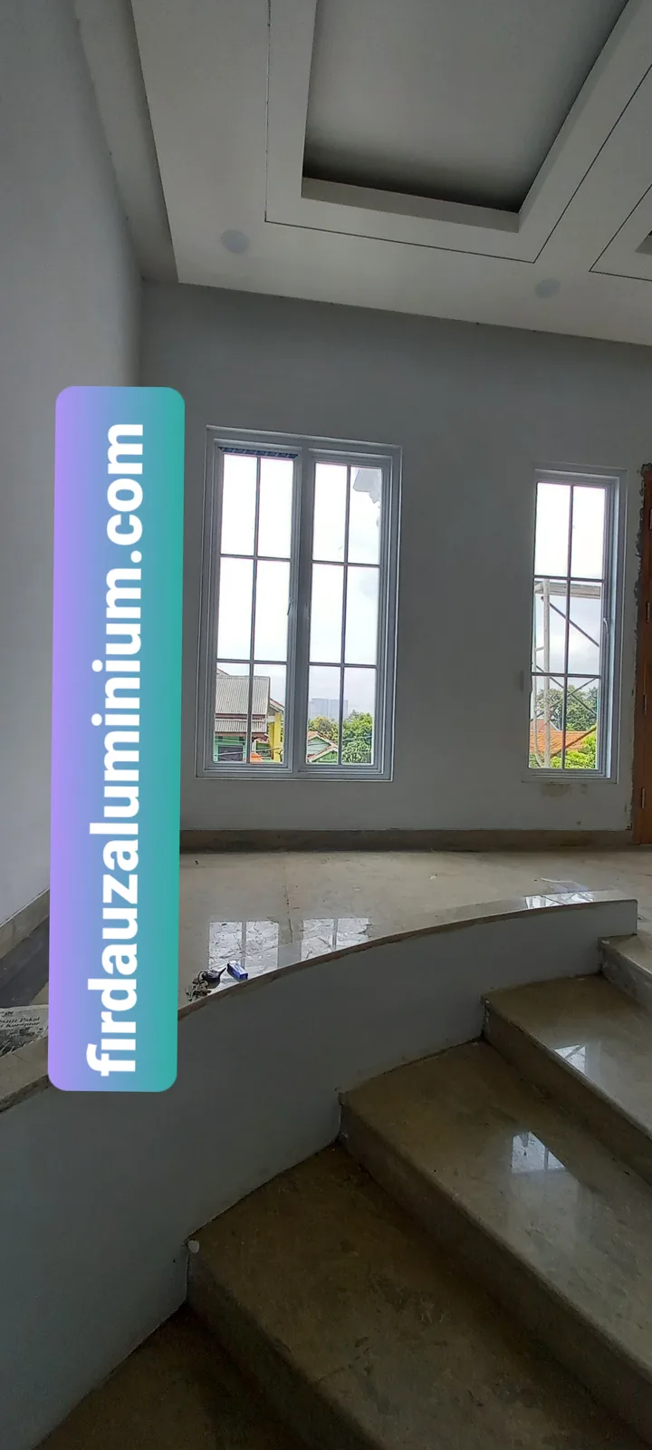 Sepasang jendela aluminium putih pada dinding dekat tangga