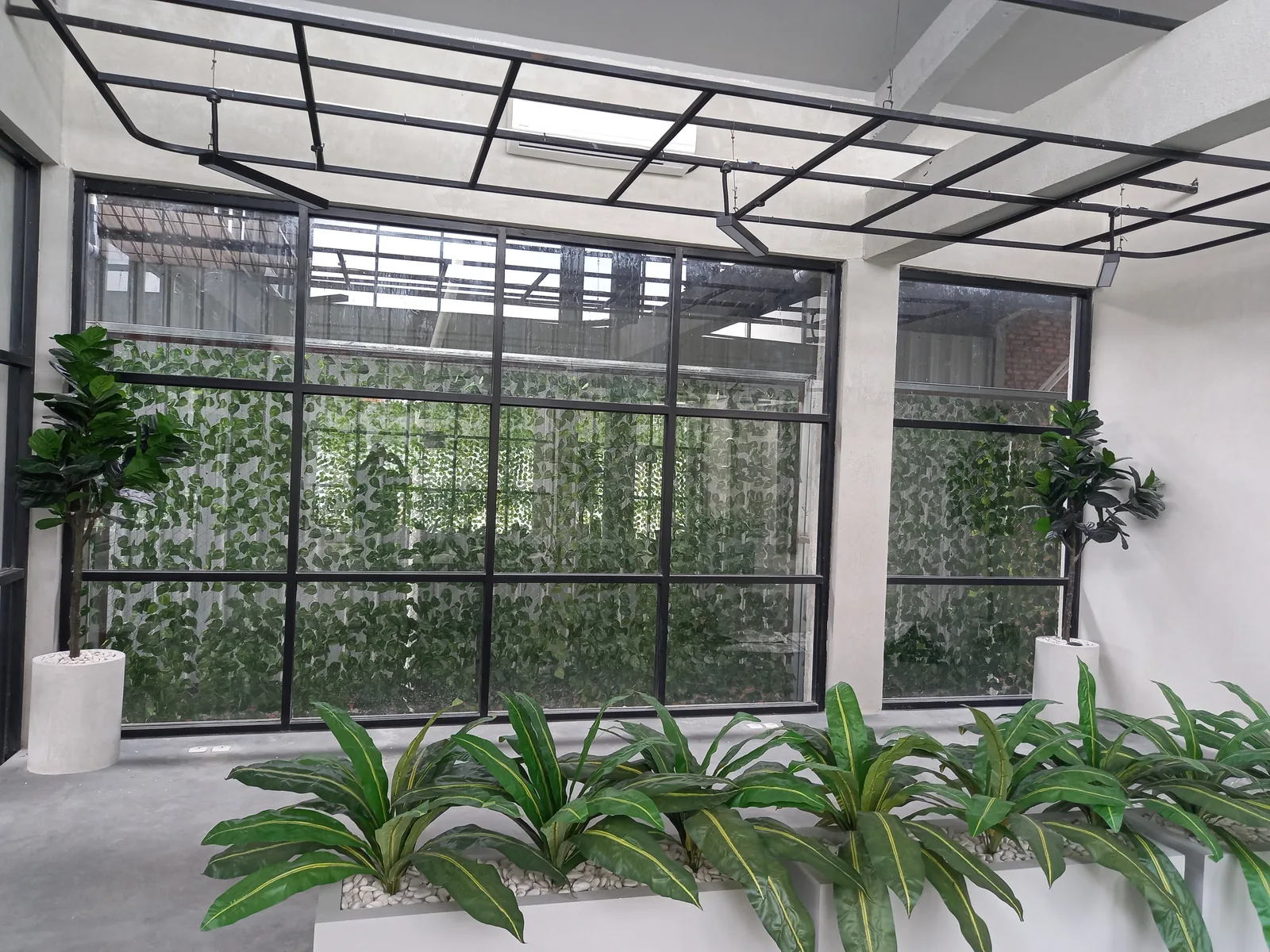 Rangka logam hitam pada area luar bangunan dari dokumentasi Firdauz Aluminium